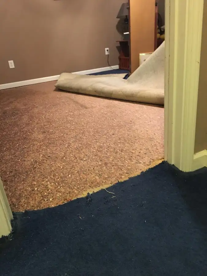 Carpet pad removal revealing water damage during Water Mitigation Services in Pittsburg